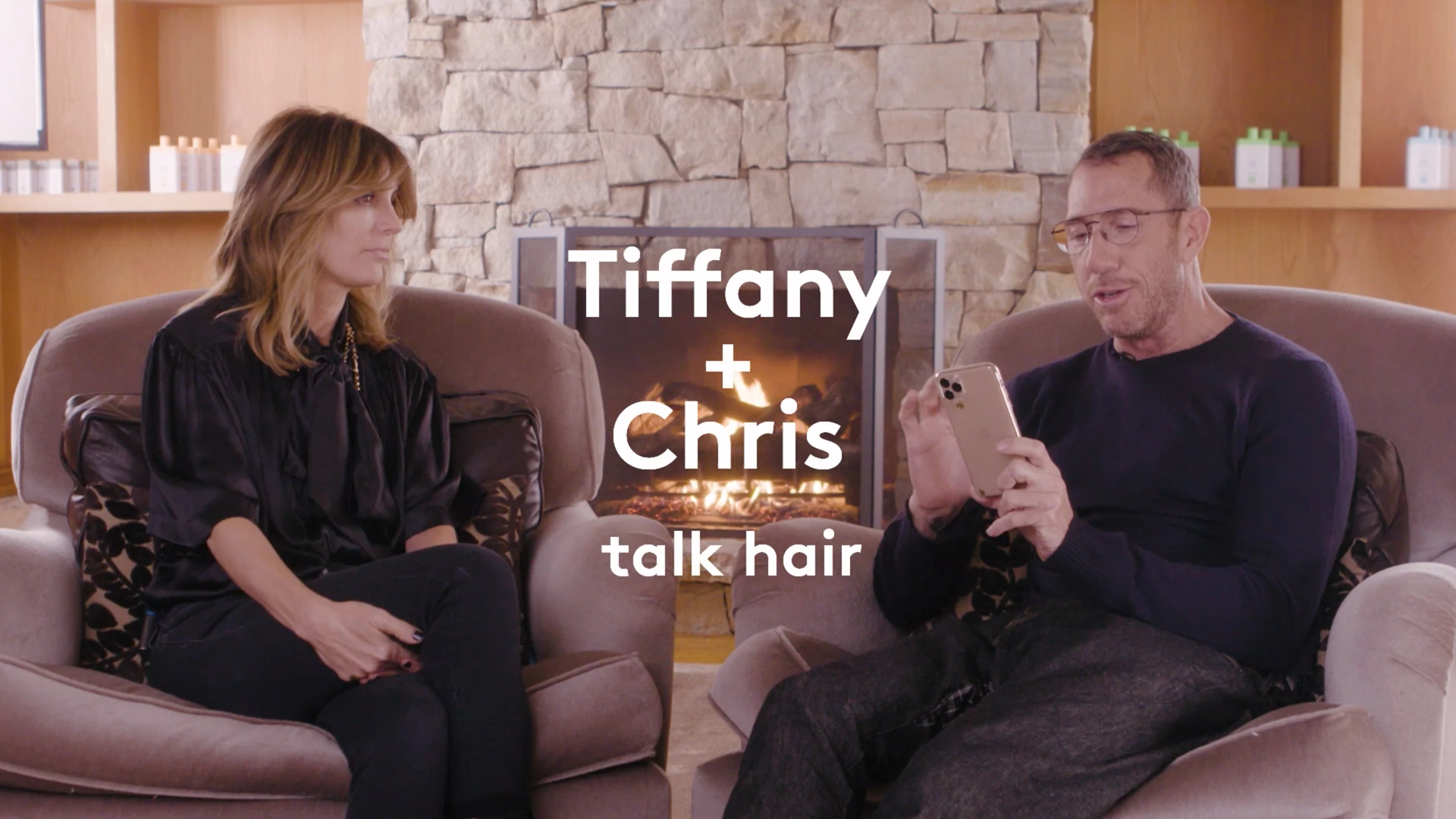 video of Drunk Elephant founder Tiffany Masterson talking to celebrity hairstylist Chris McMillan in front of a cozy fireplace